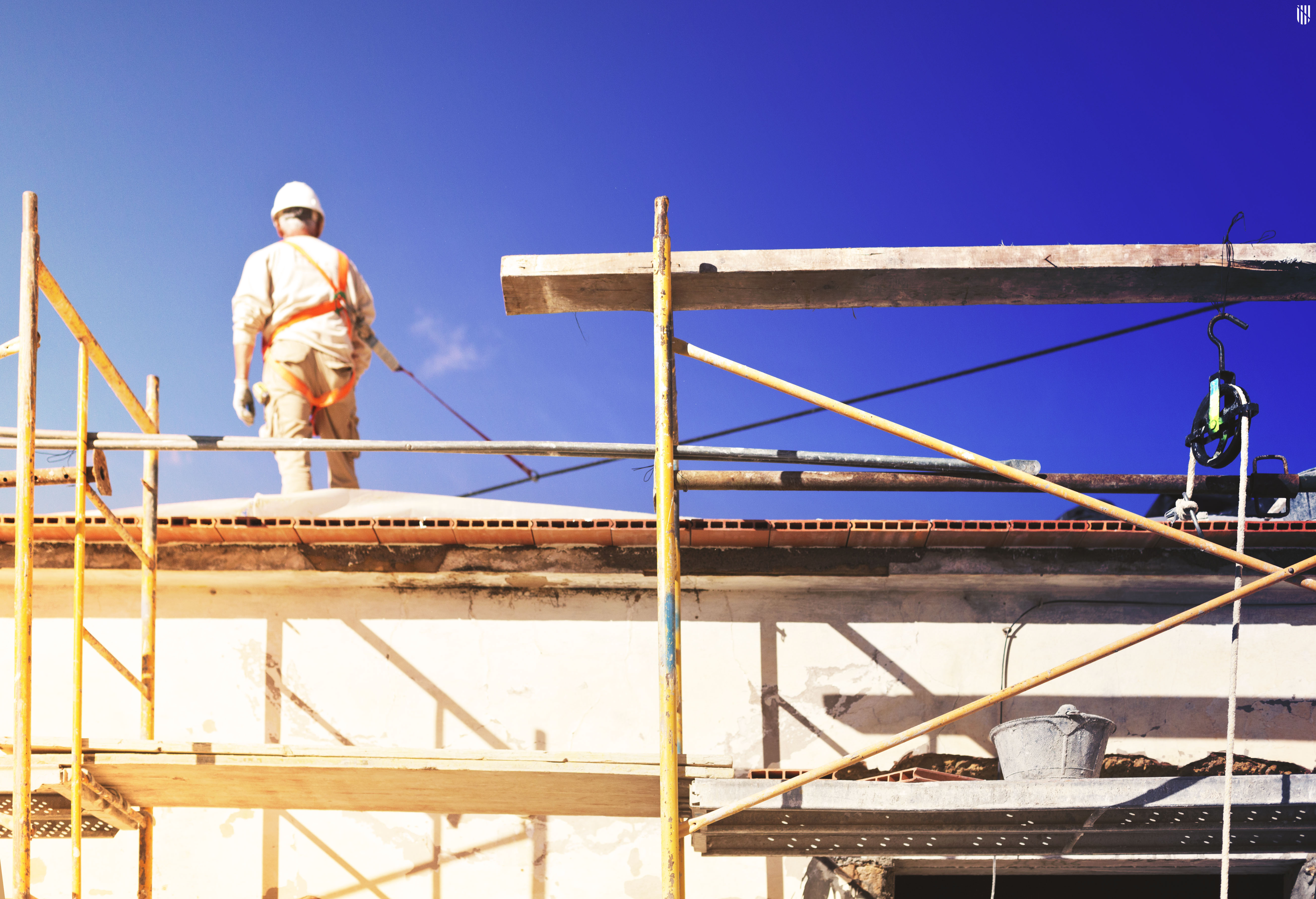 Vivienda con andamiage en la fachada y operario 