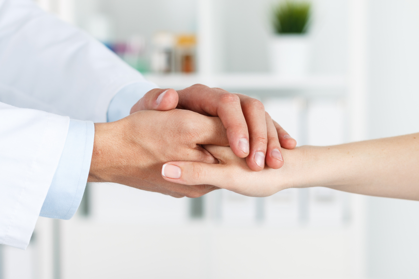 Un professional agafa la mà d'un pacient