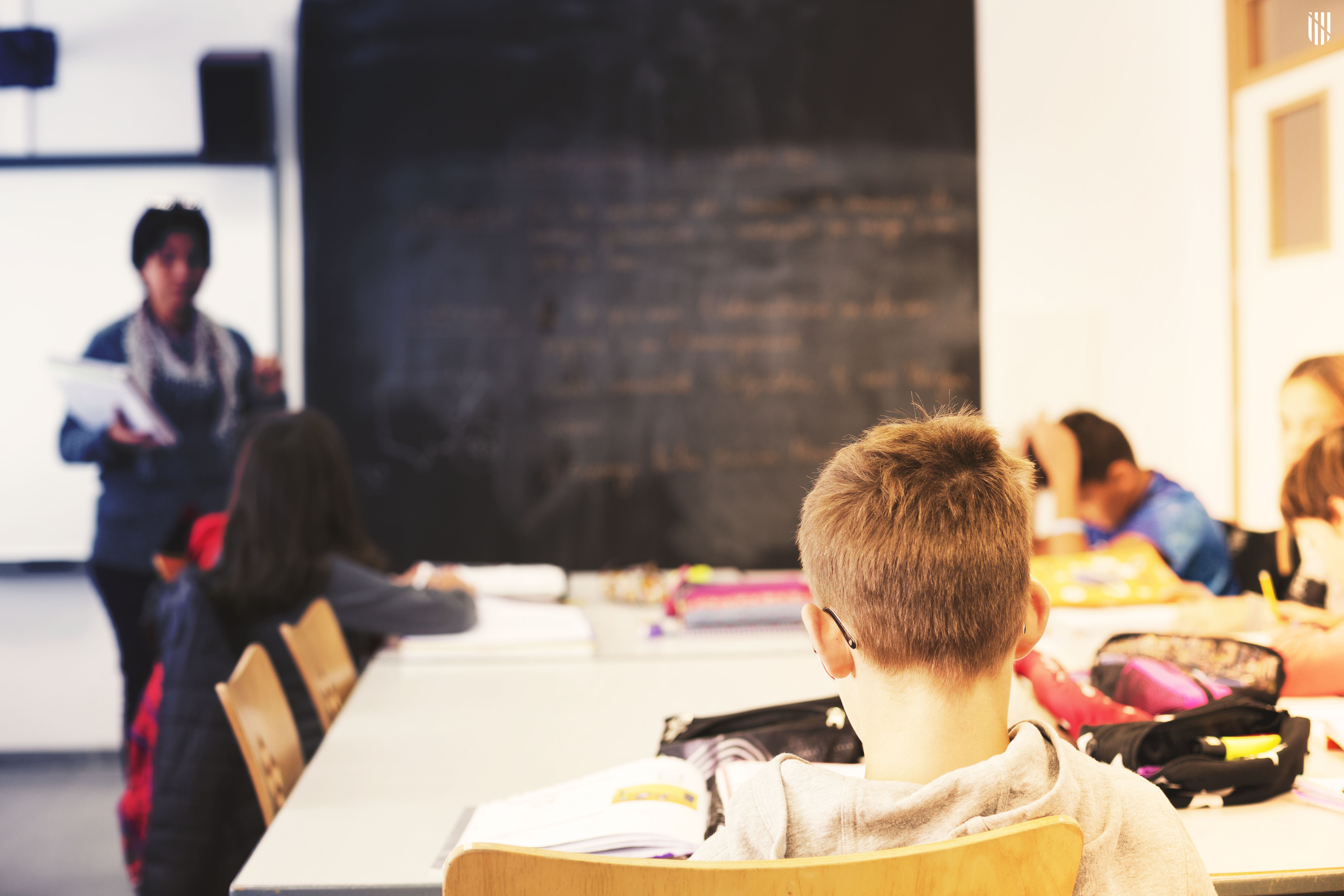 Una professora fa classe a un grup d'alumnes dins una aula