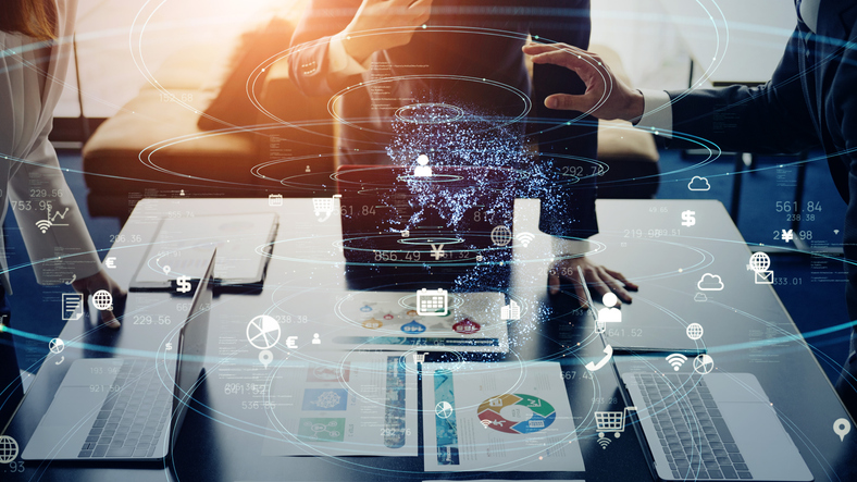 Escriptori amb ordinadors i persones treballant