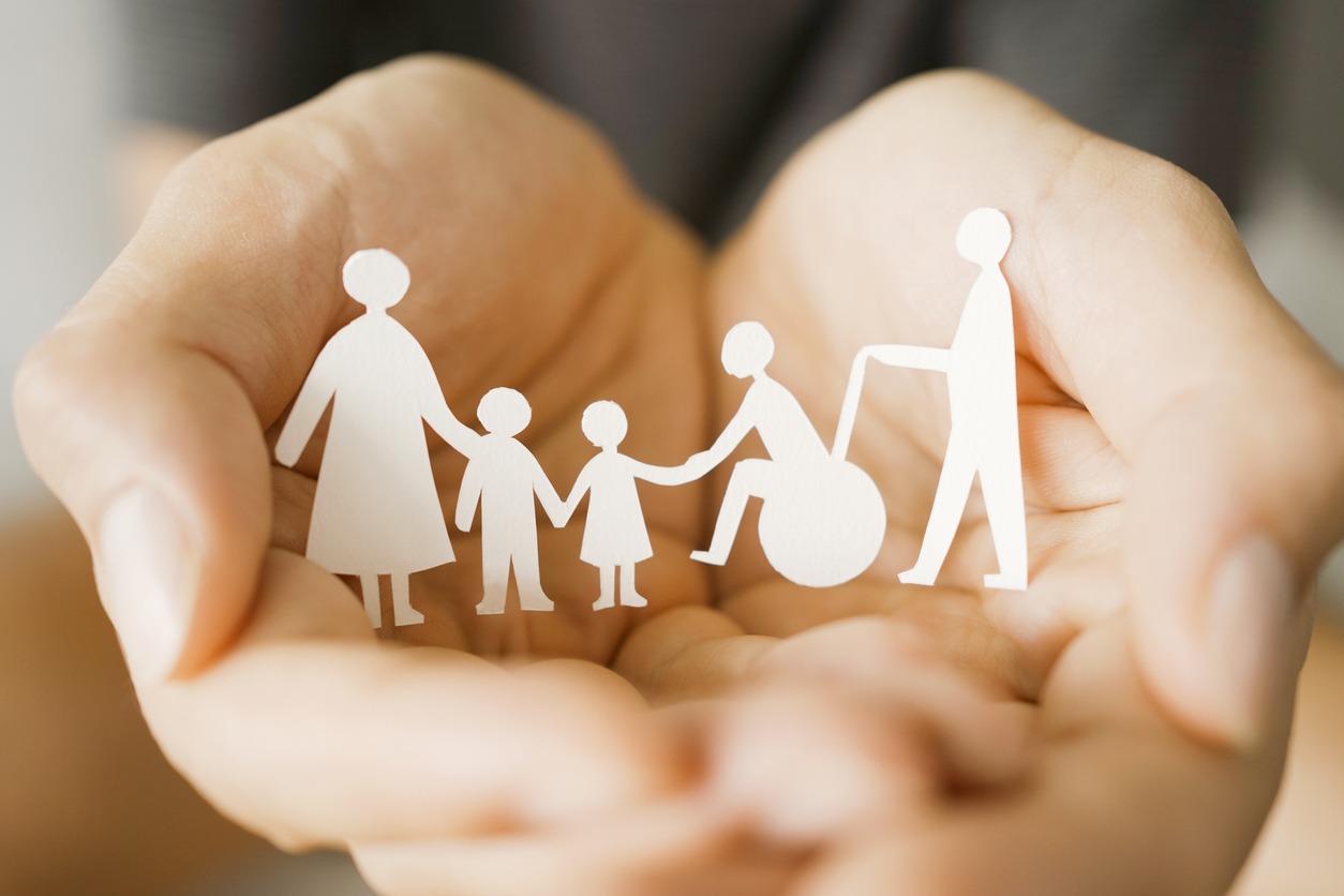 Unes mans sostenen figures de paper que representen una família