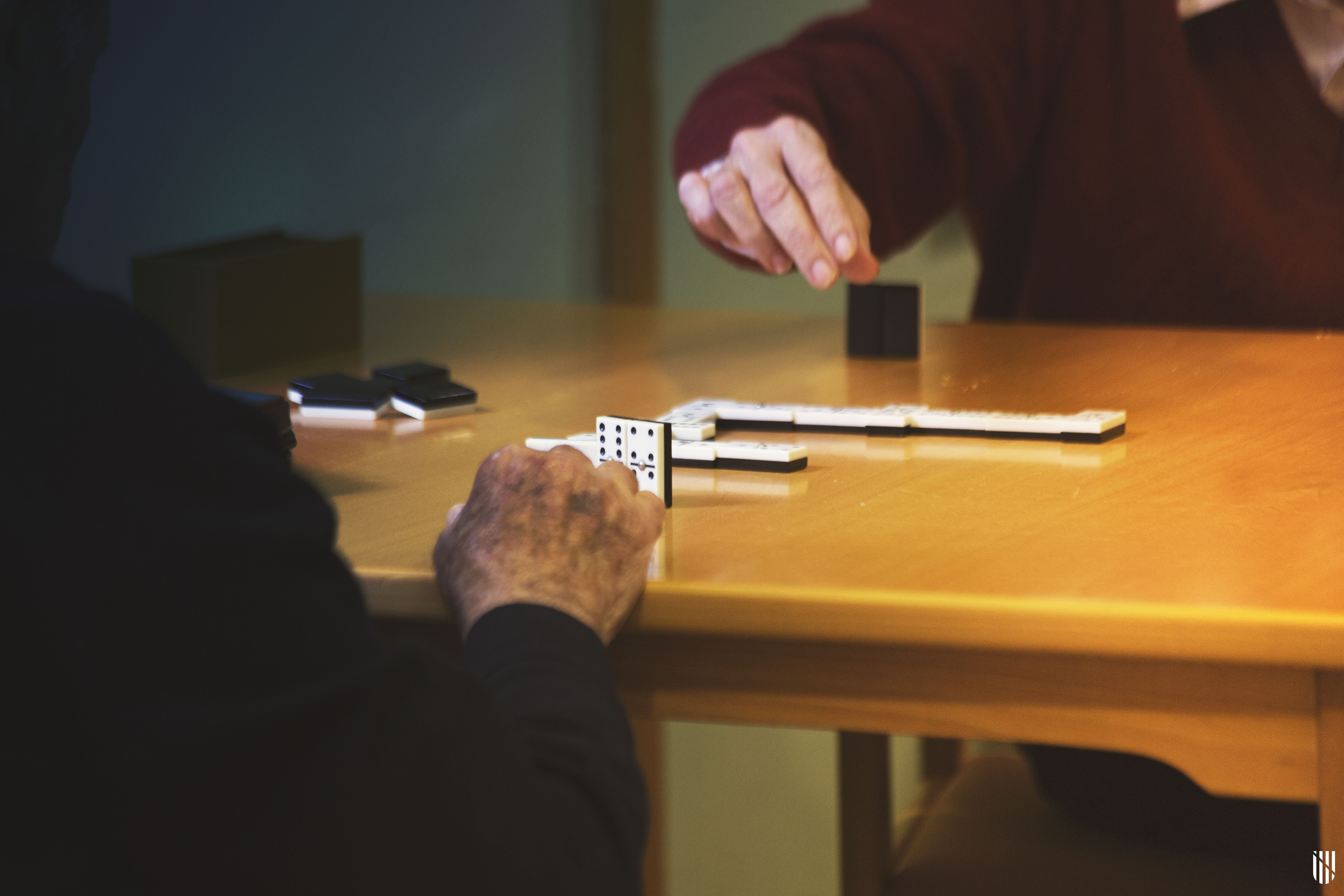 Dues persones grans jugant a domino a un centre de dia Dues persones grans jugant a domino a un centre de dia