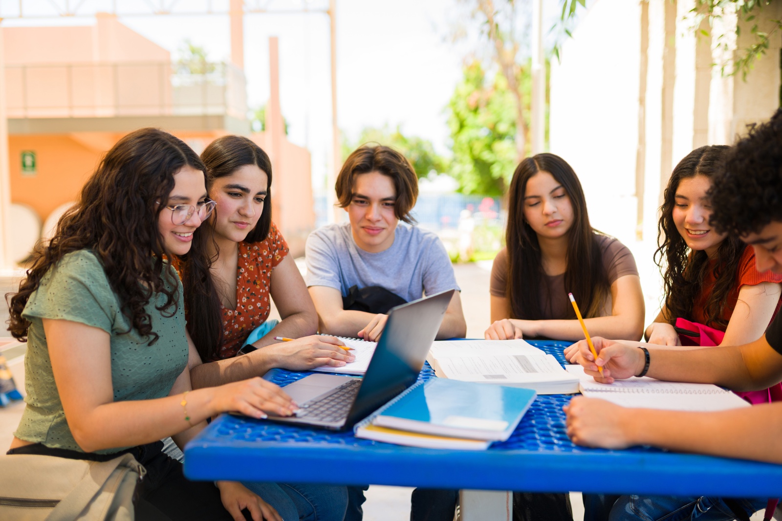 Un grup de joves mira un ordinador i repassa uns apunts