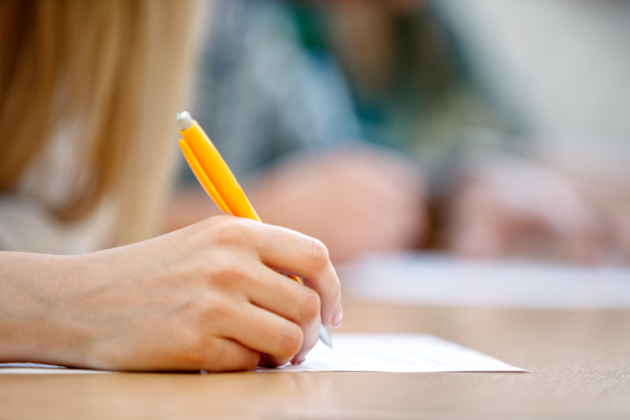 Primer pla de la mà d'una dona escribint durant un examen.