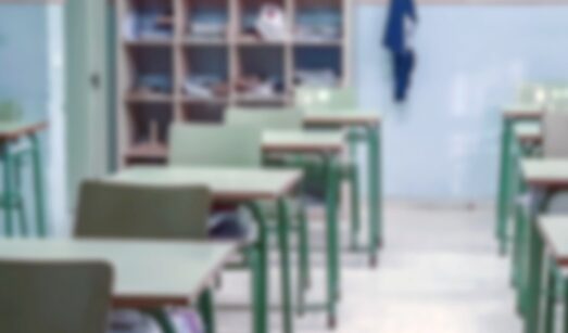Imatge d'una aula d'un col·legi amb taules i cadires, però sense alumnes